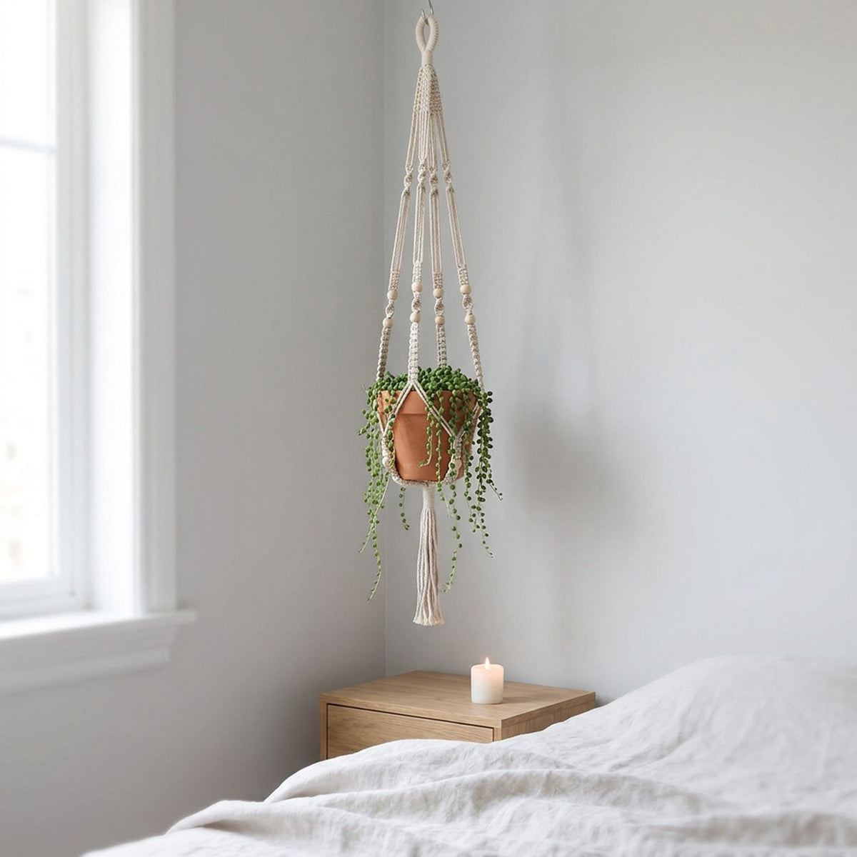 Suspension macramé blanche dans une chambre scandinave avec plante suspendue