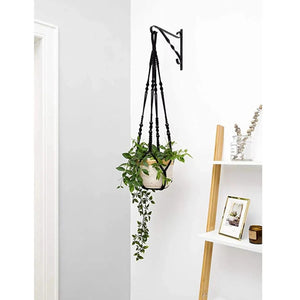Suspension macramé blanche tenant une plante en pot dans une décoration intérieure