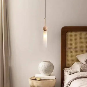 Suspension en pierre naturelle simple allumée près d'une tête de lit en cannage