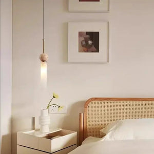 Suspension en pierre naturelle dans une chambre avec table de chevet et vase