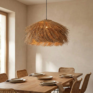 Suspension en rotin tissé suspendue au dessus d'une table de salle à manger avec chaises en rotin