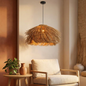 Suspension en rotin tissé éclairant un coin salon avec un fauteuil en lin et une plante verte