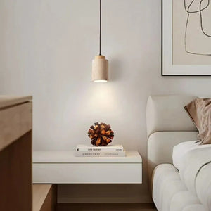 Suspension travertin Cylindre bois naturel allumée dans une chambre minimaliste blanche