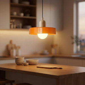 Suspension en verre orange allumée au-dessus d'un îlot de cuisine moderne
