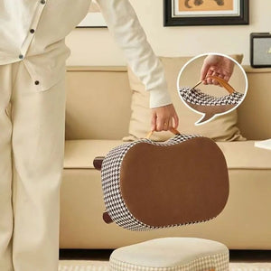 Tabouret café transporté par sa poignée en cuir dans le salon