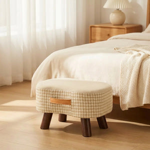 Tabouret beige au pied d'un lit dans une chambre lumineuse