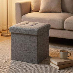 Tabouret coffre de rangement utilisé comme repose pieds devant un canapé