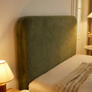 Détail de la housse de tête de lit verte en velours avec lampe de chevet le soir