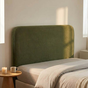 Housse de tête de lit verte en velours dans une chambre minimaliste avec table d'appoint