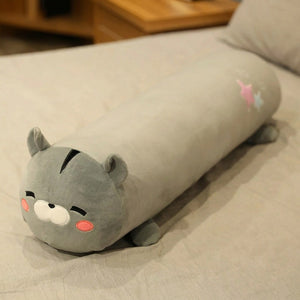 Traversin peluche en forme de chat gris kawaii posé sur un lit clair