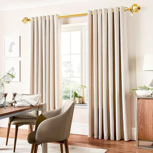Tringle à rideaux dorée avec doubles rideaux beige dans un intérieur lumineux