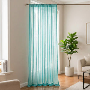 Voilage uni turquoise suspendu à une fenêtre dans un salon moderne