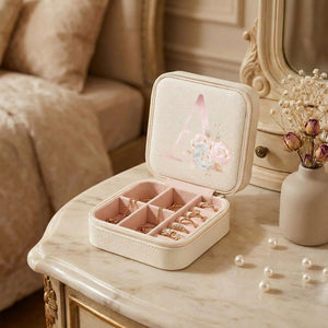 Boîte à bijoux ouverte sur une coiffeuse en marbre avec un vase de fleurs séchées et des perles