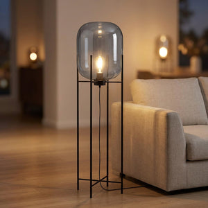 Lampadaire nordique globe en verre gris fumé allumé sur pied métal noir