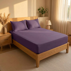 Drap-housse violet extensible sur un lit dans une chambre chaleureuse à la lumière dorée