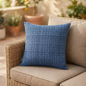 Housse de coussin d'extérieur imperméable bleue au tissage texturé sur un canapé en rotin
