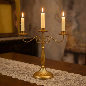 Chandelier doré trois branches avec trois bougies allumées
