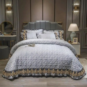Couvre-lit matelassé en velours gris à la dentelle brodée dorée sur un lit