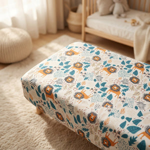 Drap housse bébé motif lion et feuillage sur un matelas de berceau