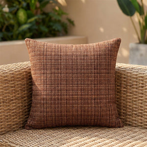 Housse de coussin d'extérieur imperméable marron au tissage texturé sur un canapé en rotin