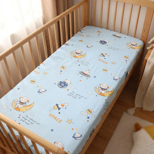 Drap housse bébé motif espace et astronaute sur un matelas de berceau
