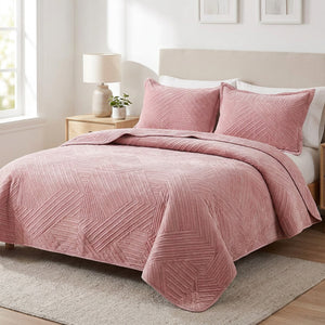 Couvre-lit matelassé en velours rose au motif géométrique brodé sur un lit