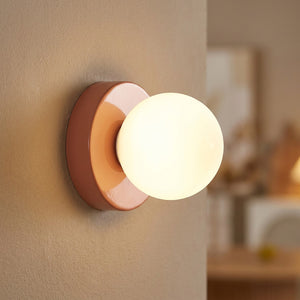 Applique murale terracotta avec globe en verre allumé gros plan