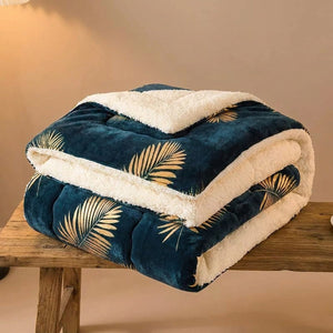 Couverture polaire motif feuilles dorées pliée montrant l'envers sherpa