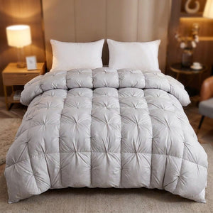 Couette en duvet matelassée gris clair posée sur un lit