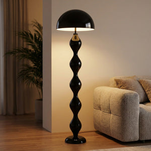 Lampadaire champignon noir allumé près d'un canapé