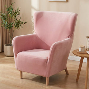 Housse de fauteuil à oreilles en velours rose sur un fauteuil une place