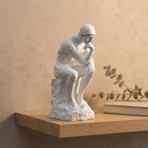 Statue Le Penseur de Rodin en résine blanche sur une étagère en bois