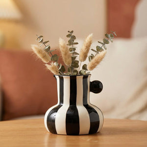 Petit vase en céramique à rayures noires avec une bille noire sur le côté
