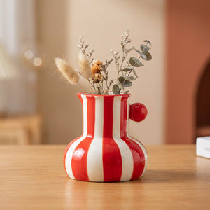 Petit vase en céramique à rayures rouges avec une bille rouge sur le côté