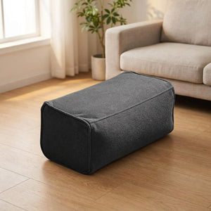 Pouf repose-pieds en chenille anthracite sur un sol en bois clair