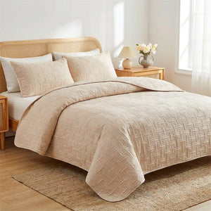 Couvre-lit matelassé tressé beige sur un lit avec deux taies d'oreiller assorties
