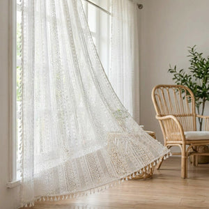 Rideau boho en dentelle au crochet blanc à pompons suspendu à une fenêtre