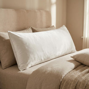 Housse de coussin en velours blanc vue de face sur un lit