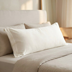 Taie d'oreiller longue en coton sateen blanche sur un lit