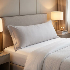 Taie d'oreiller longue en coton sateen grise sur un lit