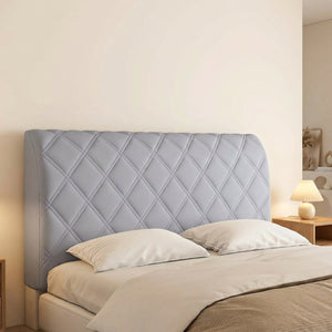 Housse de tête de lit couleur grise installée sur un lit avec lampe de chevet