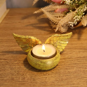 Bougeoir ailes d'ange en résine couleur jaune avec bougie allumée