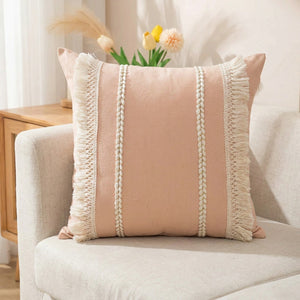 Housse de coussin bohème rose tissée à franges sur un canapé en lin