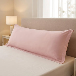 Taie de traversin longue en microfibre rose sur un lit