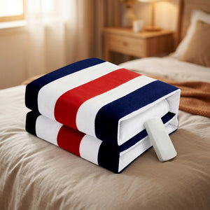 Couverture chauffante à rayures bleues blanches et rouges pliée sur un lit