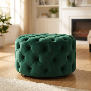 Tabouret pouf rond en velours vert foncé capitonné sur parquet
