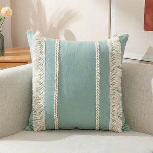 Housse de coussin bohème vert sauge tissée à franges sur un canapé en lin
