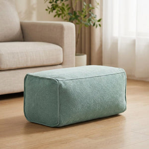 Pouf repose-pieds en chenille vert sauge dans un intérieur douillet