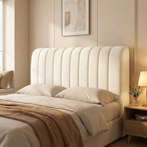 Housse de tête de lit blanche capitonnée installée sur un lit