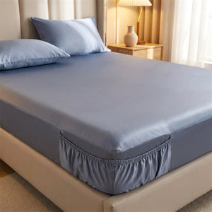 Drap housse bleu en soie installé sur un matelas dans une chambre élégante